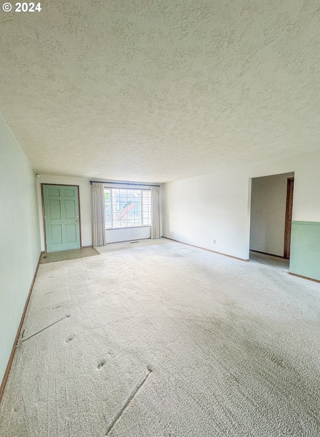 carpeted empty room with a textured ceiling