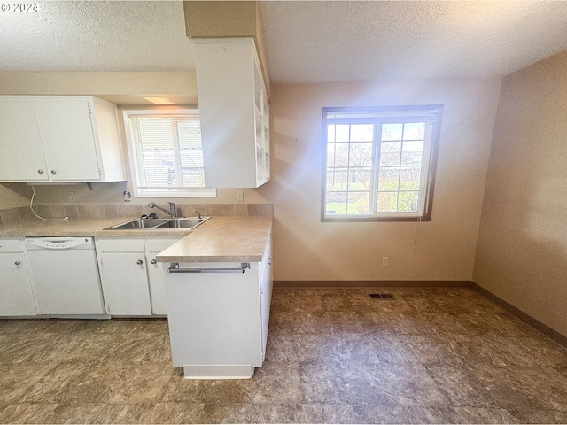 kitchen featuring white cabinets, a textured ceiling, white dishwasher, and sink