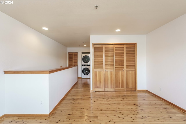 interior space with stacked washer / dryer and light hardwood / wood-style flooring