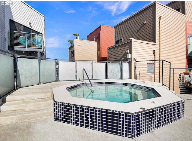 view of swimming pool with a hot tub