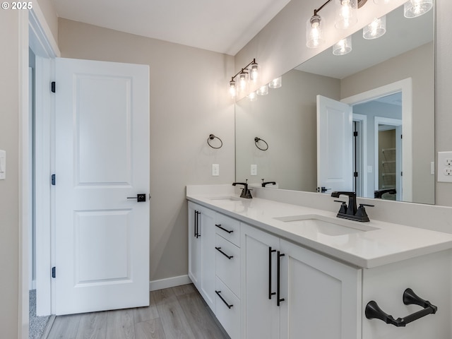 724 NW 178th Way, Ridgefield, WA 98642 - bathroom featuring double vanity, wood finished floors, and baseboards