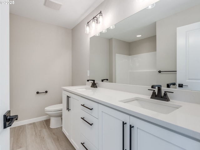 724 NW 178th Way, Ridgefield, WA 98642 - bathroom featuring toilet, baseboards, double vanity, wood finished floors, and recessed lighting