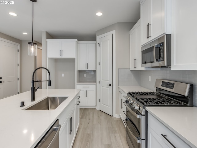 724 NW 178th Way, Ridgefield, WA 98642 - kitchen with stainless steel appliances, a sink, recessed lighting, light wood-style flooring, and white cabinetry