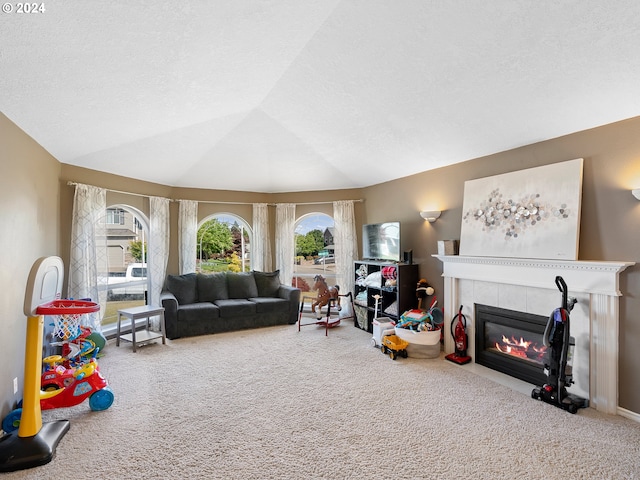 playroom with carpet, vaulted ceiling, and a tile fireplace