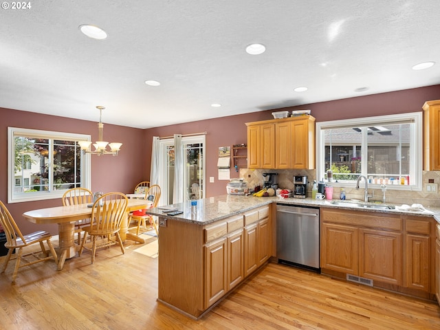 kitchen with dishwasher, sink, kitchen peninsula, a chandelier, and light wood-type flooring