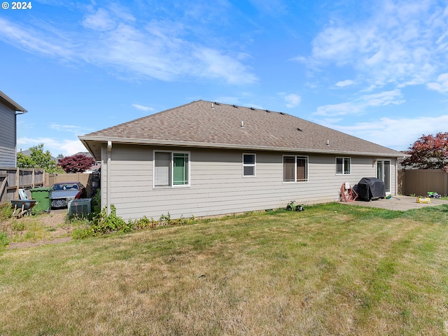 rear view of property featuring a lawn