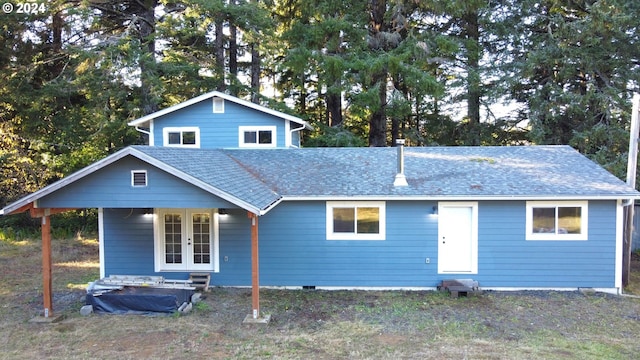 view of front facade featuring french doors and roof with shingles