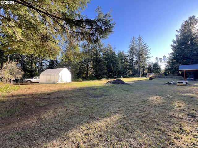 view of yard with an outdoor structure and a greenhouse