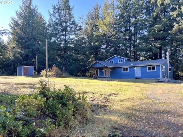 view of front of property featuring an outbuilding, crawl space, a storage shed, and a front yard