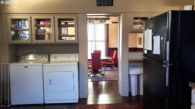 laundry area featuring washing machine and clothes dryer and dark hardwood / wood-style flooring