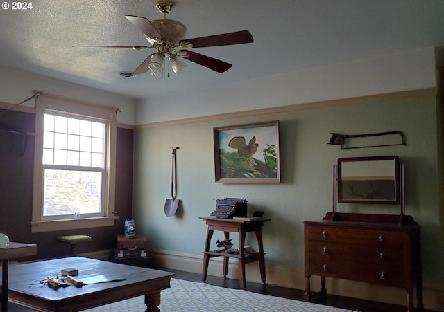 living room with ceiling fan and a textured ceiling