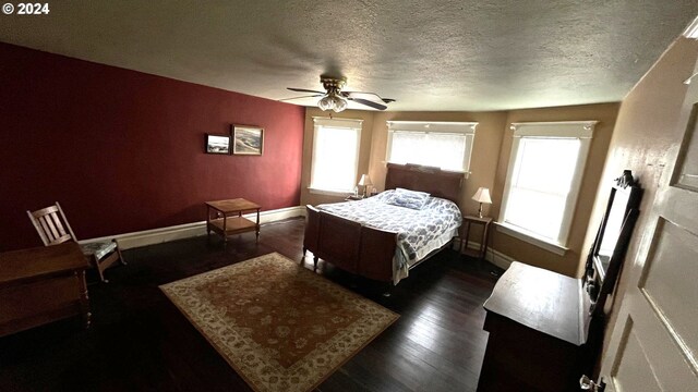 bedroom with ceiling fan, dark hardwood / wood-style floors, and a textured ceiling