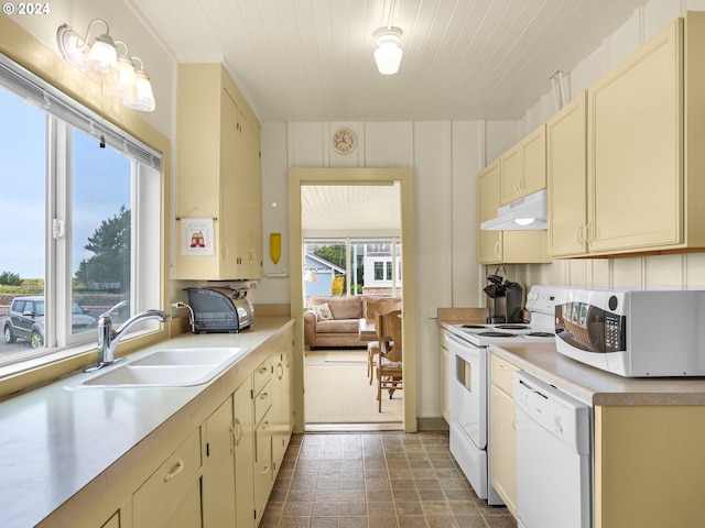 kitchen with a wealth of natural light, sink, hanging light fixtures, and white appliances