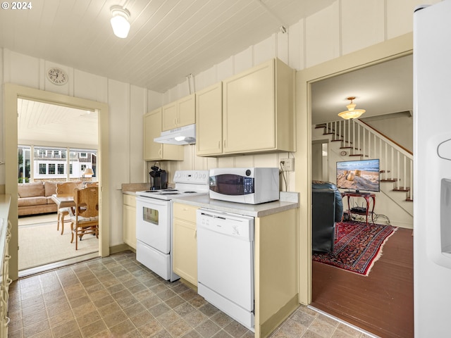 kitchen with light hardwood / wood-style floors, white appliances, and cream cabinetry