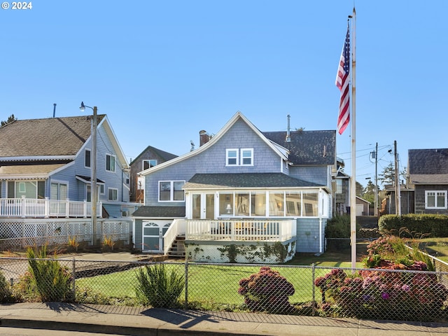 view of front of house with a front lawn and a sunroom