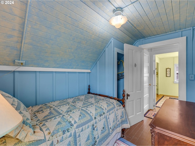 bedroom with vaulted ceiling and dark hardwood / wood-style floors