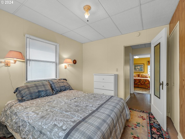 bedroom featuring a paneled ceiling and hardwood / wood-style flooring