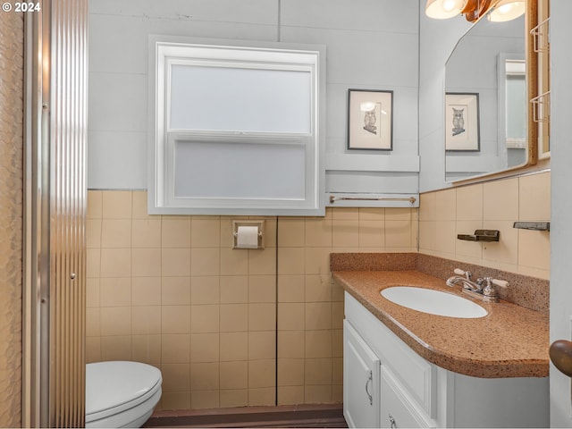 bathroom with vanity, tile walls, and toilet