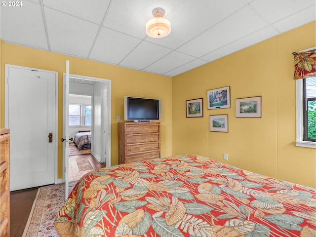 bedroom featuring a drop ceiling and wood-type flooring