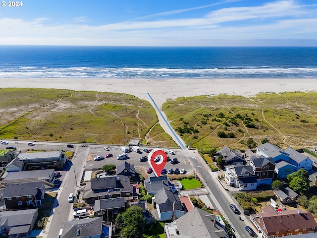 birds eye view of property with a water view and a beach view