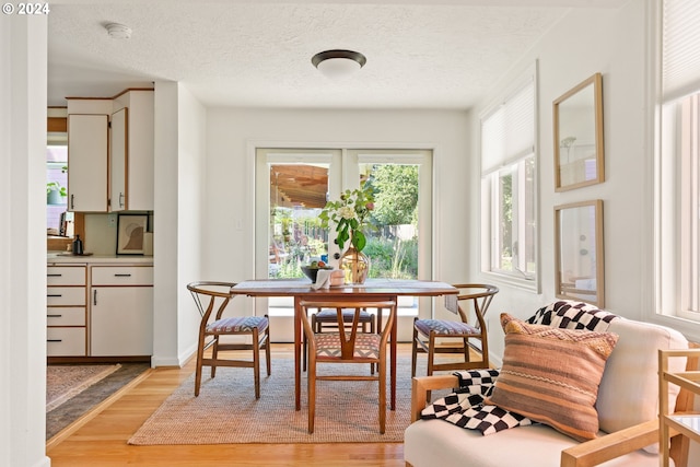 dining room featuring light hardwood / wood-style floors and a textured ceiling