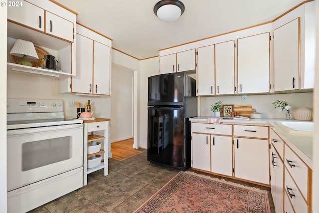 kitchen with white cabinetry, black fridge, and electric range