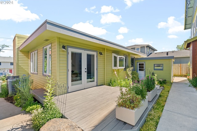 rear view of property with a wooden deck and french doors