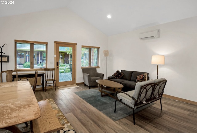 living room with dark wood-type flooring, high vaulted ceiling, a wealth of natural light, and a wall unit AC