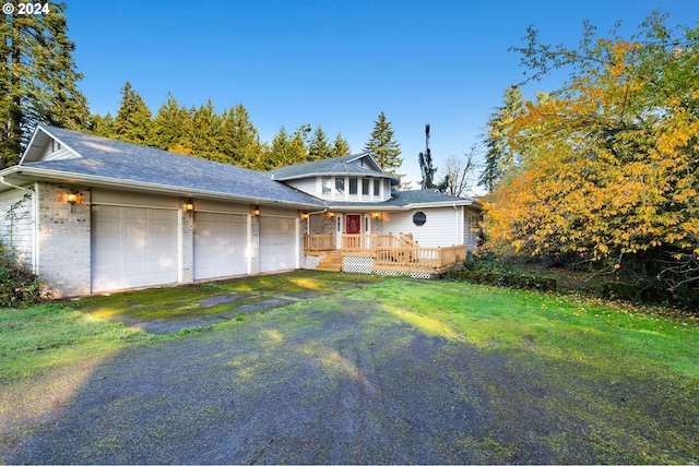 view of front facade featuring a deck, a garage, and a front yard