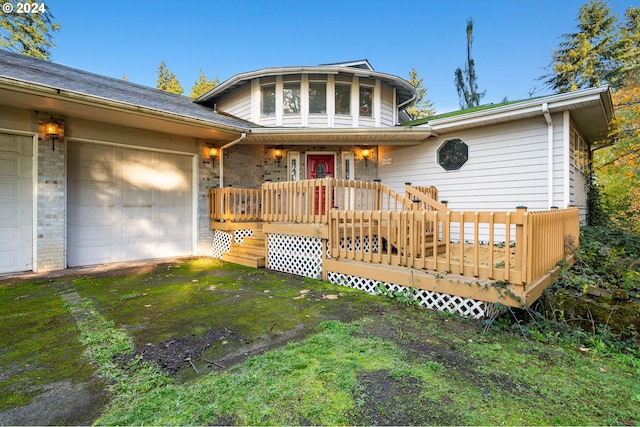 view of front of property with a garage, a front lawn, and a deck