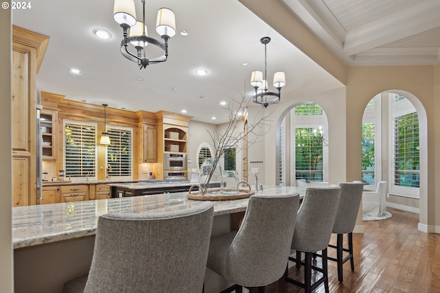 dining space with dark hardwood / wood-style floors and a notable chandelier