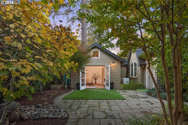 back of property featuring a patio area and a lawn