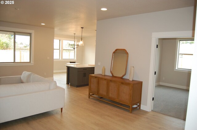 living room with light wood-type flooring and an inviting chandelier