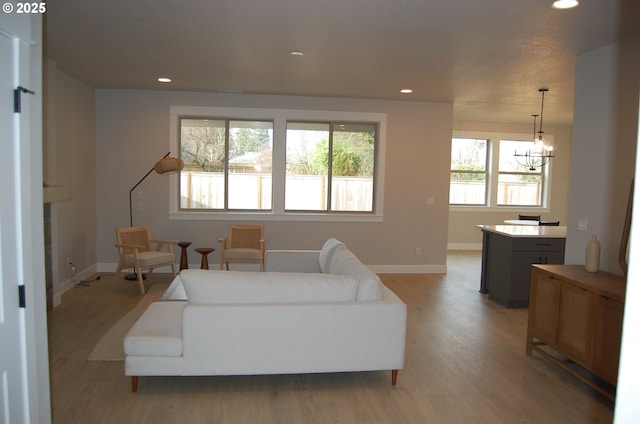 living room with light wood-type flooring and an inviting chandelier