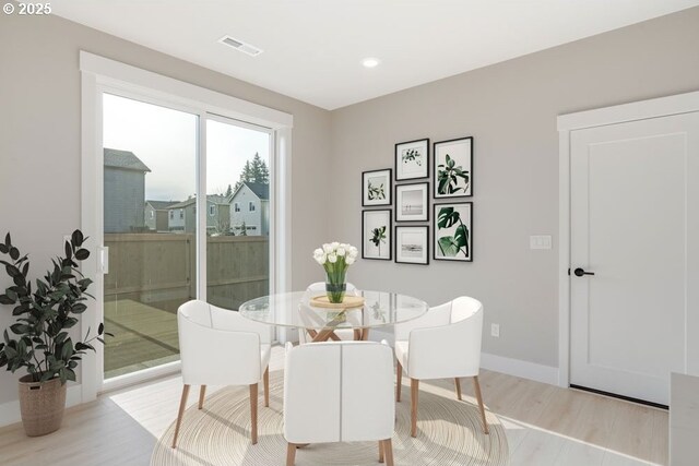 kitchen with kitchen peninsula, a kitchen bar, backsplash, white refrigerator, and white cabinetry