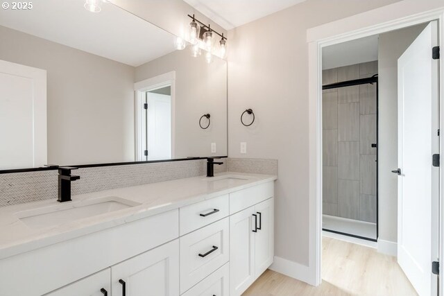 bathroom featuring backsplash, a shower, vanity, and wood-type flooring