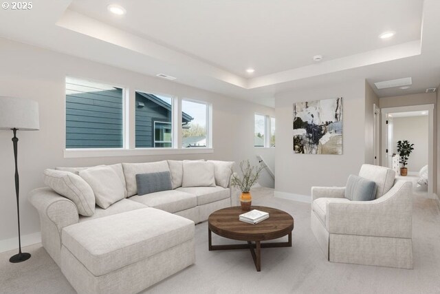 living room featuring a tray ceiling and light colored carpet