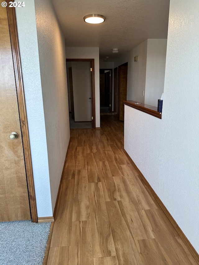 corridor with light hardwood / wood-style floors