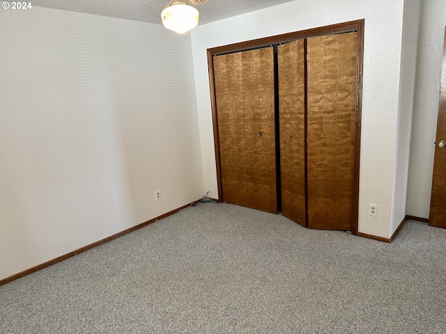 unfurnished bedroom featuring light colored carpet and a closet