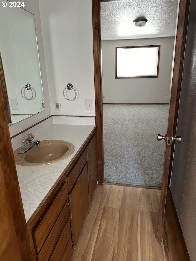 bathroom featuring hardwood / wood-style floors, vanity, and a textured ceiling