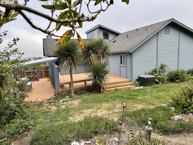 exterior space with a yard, a deck, and central AC unit