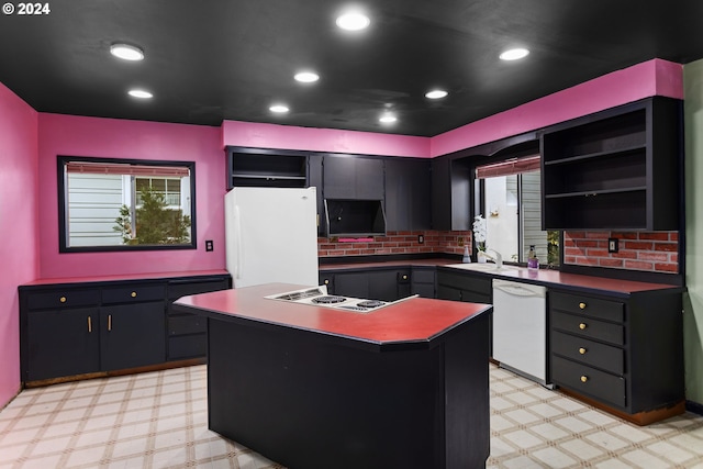 kitchen with white appliances, sink, a center island, and plenty of natural light