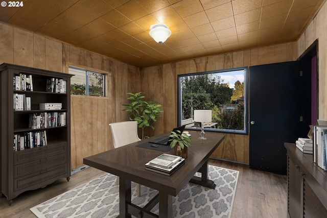 office space with light hardwood / wood-style floors and wooden walls