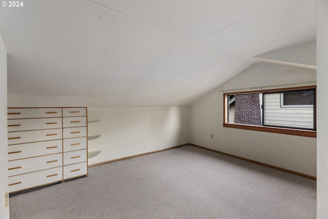 bonus room featuring light carpet and vaulted ceiling