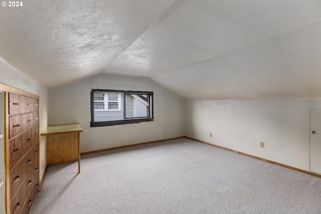 bonus room with light colored carpet, a textured ceiling, and lofted ceiling