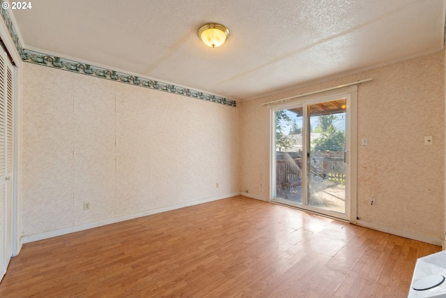 spare room with a textured ceiling and hardwood / wood-style flooring