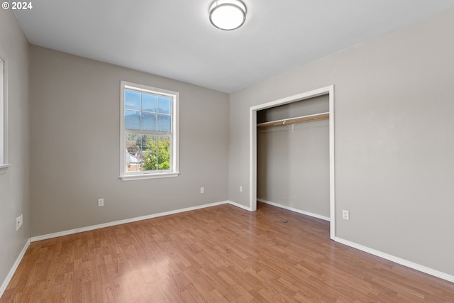 unfurnished bedroom with light hardwood / wood-style floors and a closet