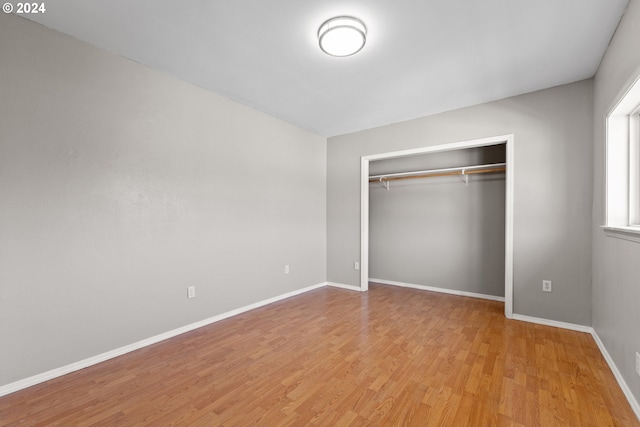 unfurnished bedroom featuring a closet and light wood-type flooring