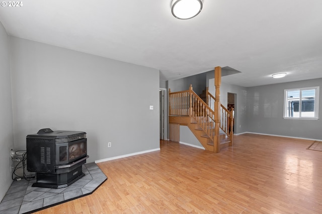 living room with light hardwood / wood-style floors and a wood stove