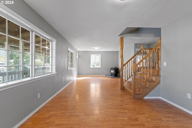 interior space with light hardwood / wood-style floors and a wood stove